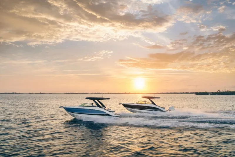 Slide: The Image of 2023 Sea Ray SLX 260 boats cruising at sunset on open water. - 30
