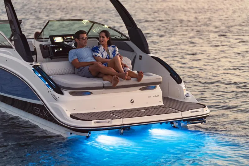 Slide: The Image of 2023 Sea Ray SLX 260 boat with couple relaxing on deck at sunset. - 8