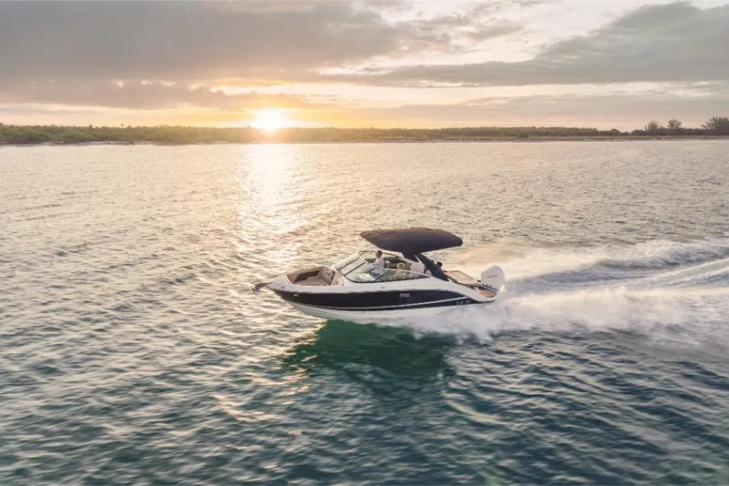 Slide: The Image of 2023 Sea Ray SLX 260 OB cruising at sunset on open water. - 23