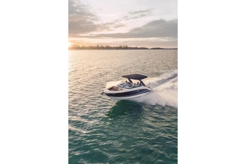 Slide: The Image of 2023 Sea Ray SLX 260 OB cruising on open water at sunset. - 24