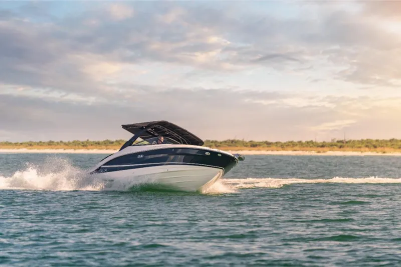 Slide: The Image of 2023 Sea Ray SLX 260 OB cruising on open water at sunset. - 25