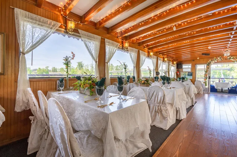 Slide: The Image of Elegant dining area on 1990 Howdy Eidelman Sternwheeler, featuring white table settings and wooden beams. - 12