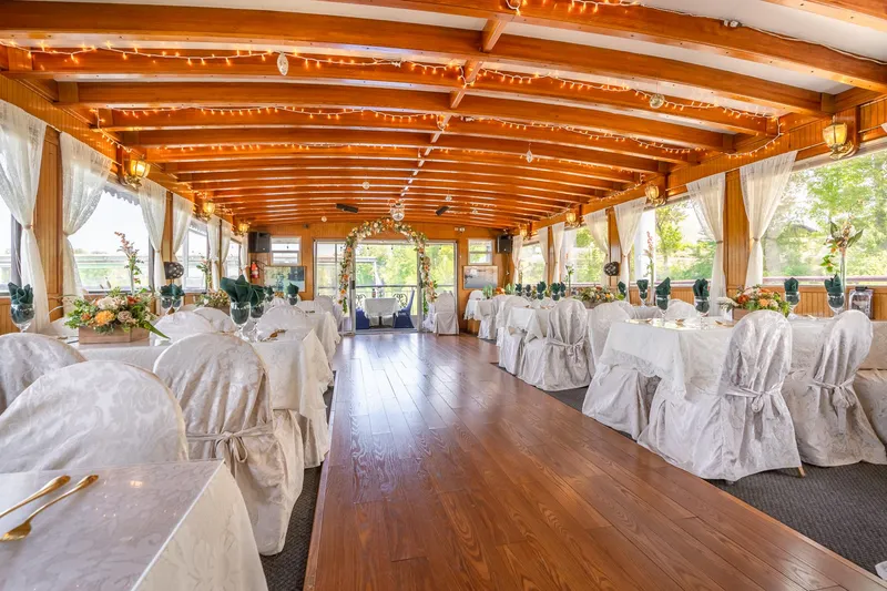 Slide: The Image of Elegant dining area on 1990 Custom Howdy Eidelman Sternwheeler, featuring white table settings and wooden ceiling. - 13