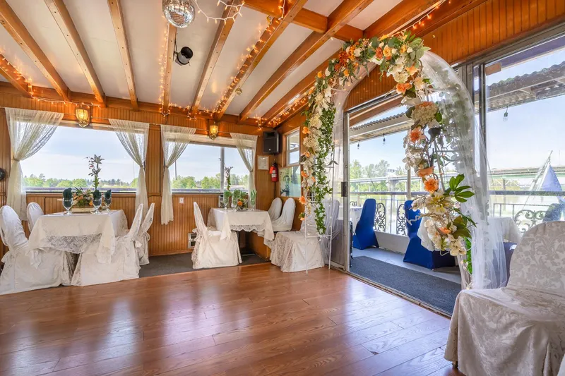 Slide: The Image of Luxurious 1990 Custom Howdy Eidelman Sternwheeler interior with elegant floral arch and decorated tables. - 16