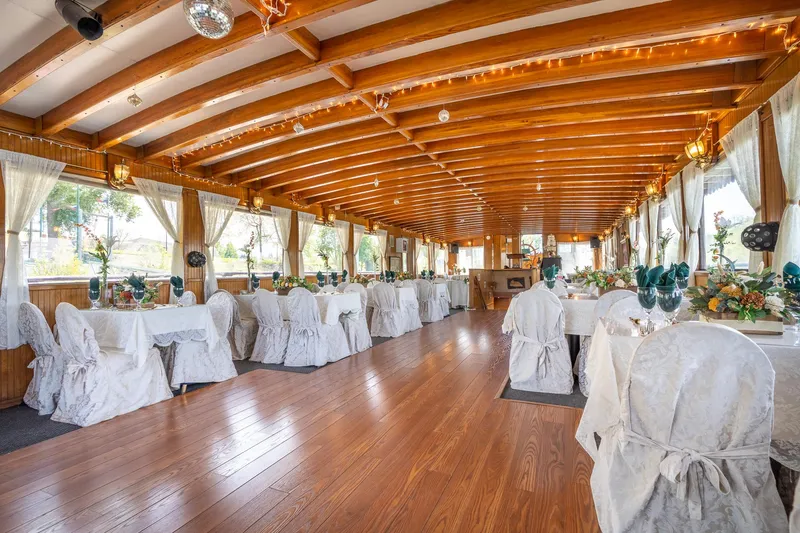 Slide: The Image of Elegant dining area on 1990 Custom Howdy Eidelman Sternwheeler, featuring wooden beams and decorated tables. - 18