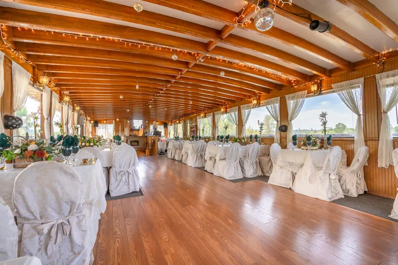 Slide: The Image of Elegant interior of 1990 Custom Howdy Eidelman Sternwheeler, featuring decorated tables and wooden beams. - 19