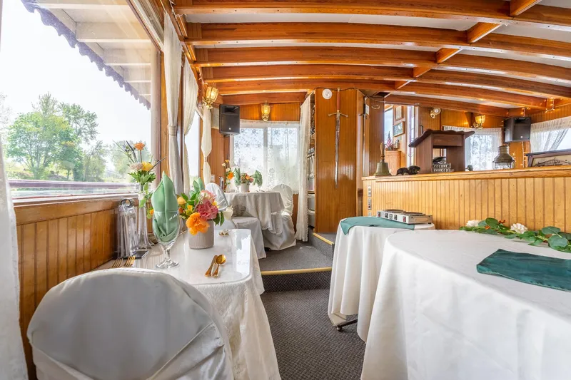 Slide: The Image of Elegant interior of 1990 Custom Howdy Eidelman Sternwheeler, featuring wooden beams and decorated tables. - 21