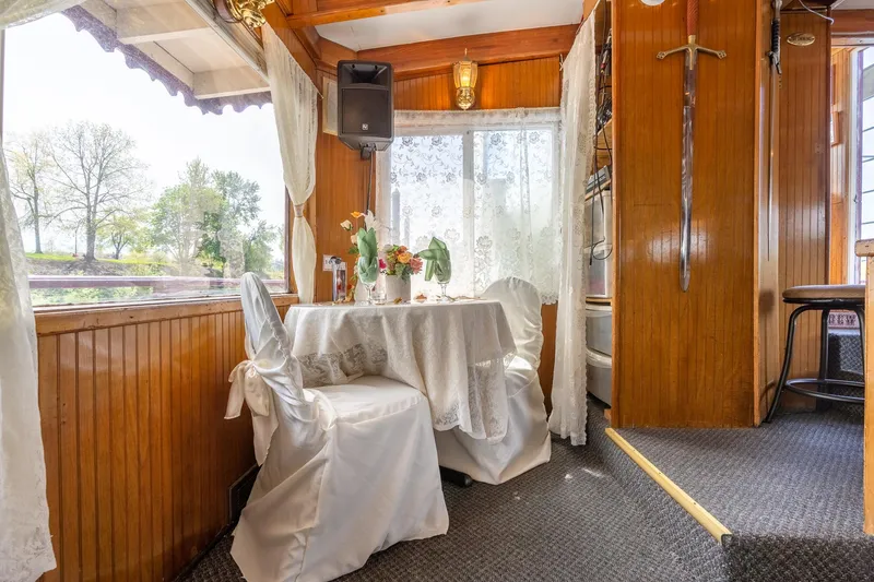 Slide: The Image of Elegant dining area on 1990 Custom Howdy Eidelman Sternwheeler, featuring wooden interior and floral decor. - 22