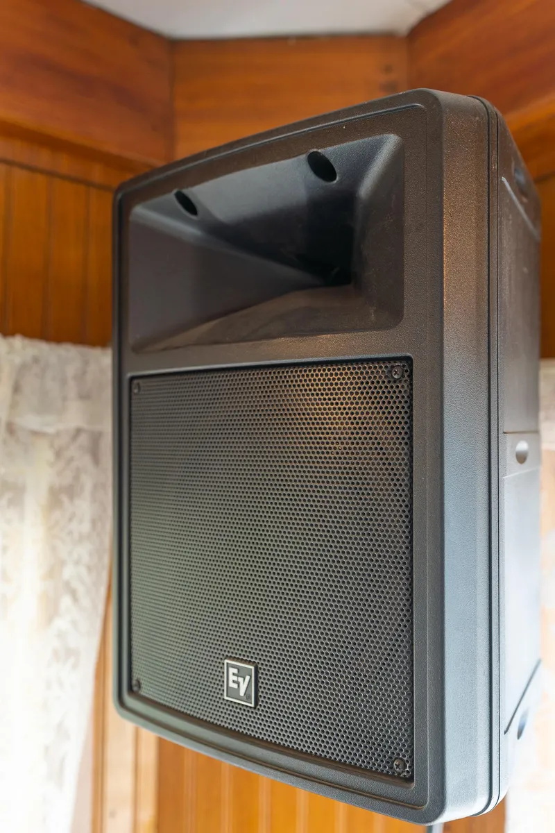 Slide: The Image of Black speaker mounted on wooden wall, featuring EV logo, in a vintage setting. - 26