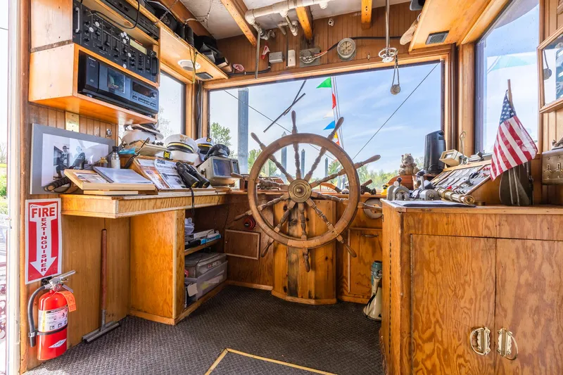 Slide: The Image of Pilot house of 1990 Howdy Eidelman Sternwheeler, featuring wooden helm and nautical decor. - 28