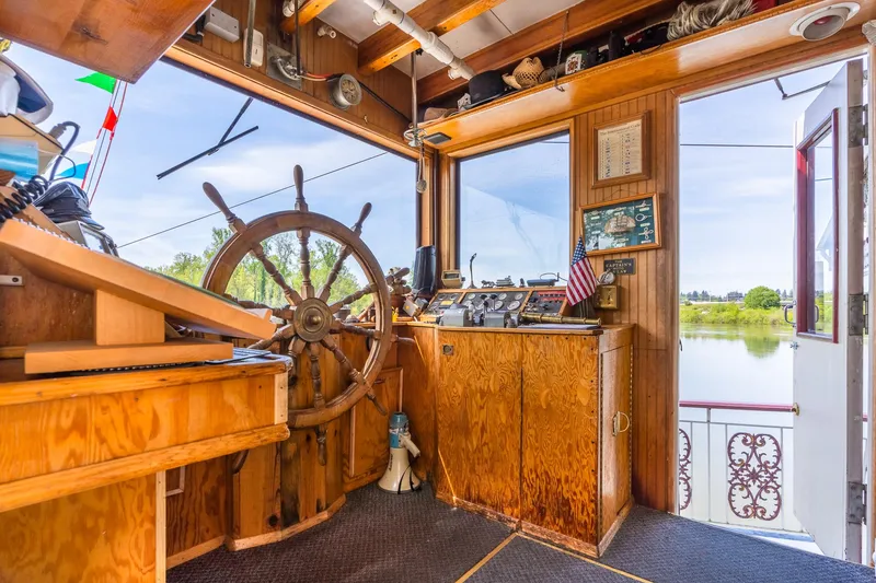 Slide: The Image of Pilot house of 1990 Custom Howdy Eidelman Sternwheeler, featuring wooden helm and control panel. - 29