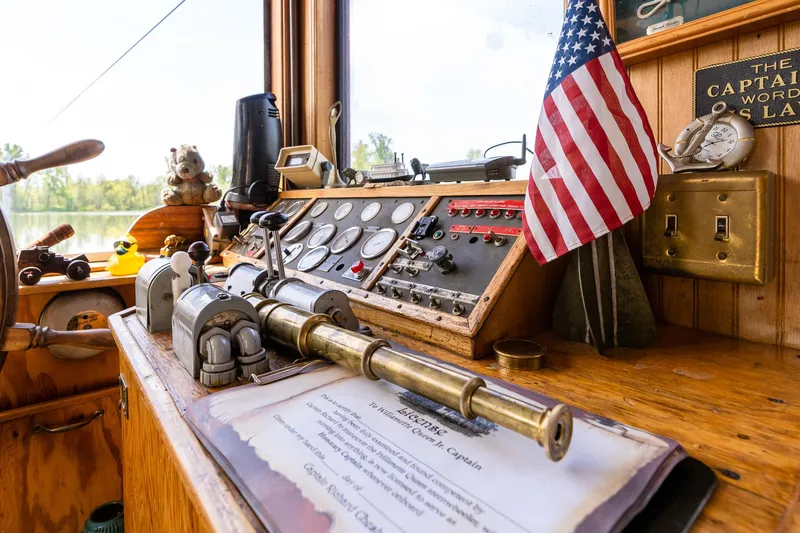 Slide: The Image of Captain's cabin of 1990 Custom Howdy Eidelman Sternwheeler, featuring vintage controls and American flag. - 35