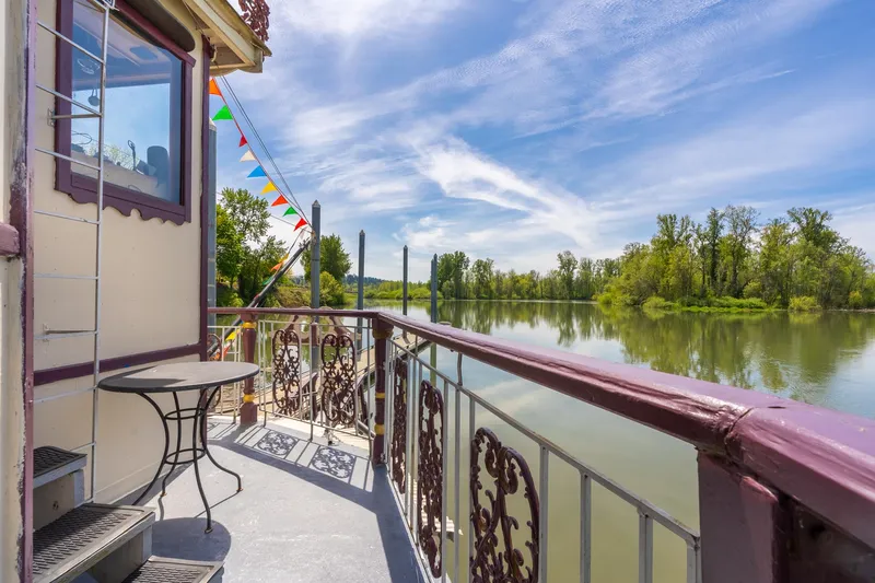 Slide: The Image of Balcony view from 1990 Custom Howdy Eidelman Sternwheeler, overlooking serene river and lush greenery. - 40
