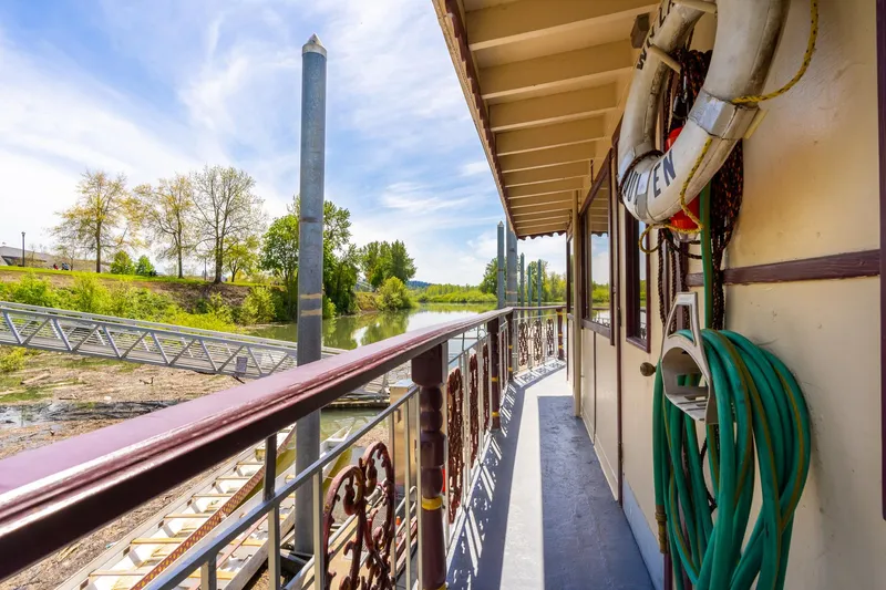 Slide: The Image of Side view of 1990 Custom Howdy Eidelman Sternwheeler, docked with scenic river backdrop. - 44