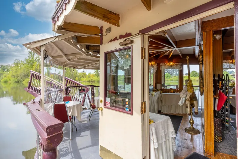Slide: The Image of Sternwheeler boat with open deck dining area, featuring elegant table settings and scenic river views. - 6