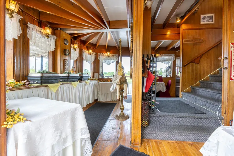 Slide: The Image of Elegant interior of 1990 Custom Howdy Eidelman Sternwheeler, featuring wood paneling and dining setup. - 7