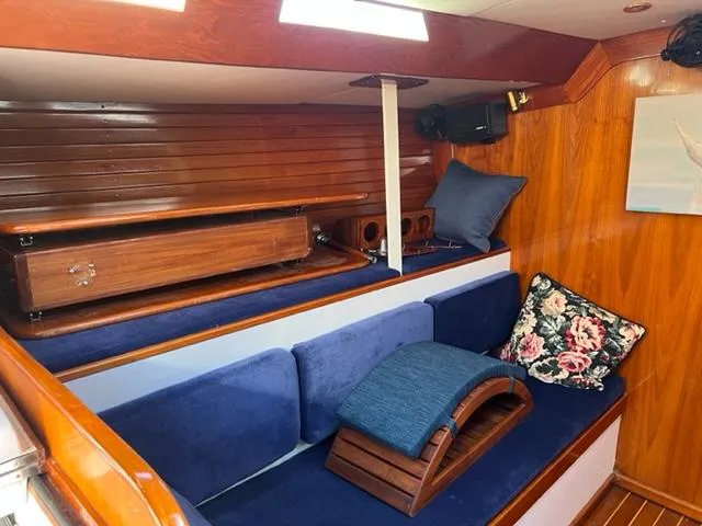 Slide: The Image of Interior of 1979 Palmer Johnson New York 40 Sloop with blue cushions and wooden accents. - 11