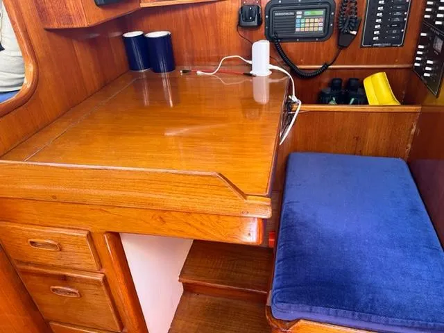 Slide: The Image of Interior of 1979 Palmer Johnson New York 40 Sloop with wooden desk and blue cushioned seat. - 13