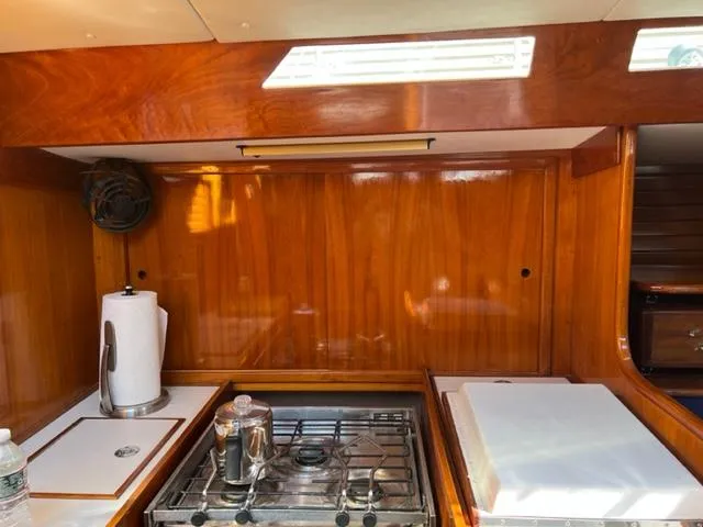 Slide: The Image of Interior of 1979 Palmer Johnson New York 40 Sloop, featuring a compact wooden galley. - 19