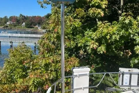 Slide: The Image of Palmer Johnson New York 40 Sloop, 1979, docked near lush greenery and waterfront. - 47