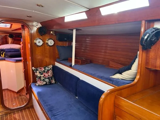 Slide: The Image of Interior of 1979 Palmer Johnson New York 40 Sloop with blue seating and wooden accents. - 6