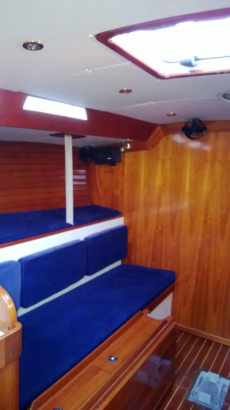 Slide: The Image of Interior of 1979 Palmer Johnson New York 40 Sloop with blue seating and wooden paneling. - 9