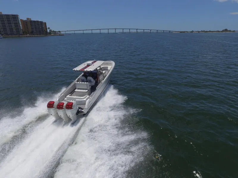 Slide: The Image of 2017 Nor-Tech 390 Sport boat cruising on open water with bridge in background. - 11