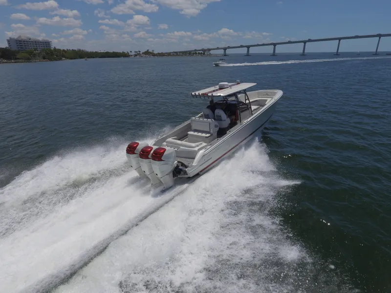 Slide: The Image of 2017 Nor-Tech 390 Sport boat speeding on water near a bridge. - 13