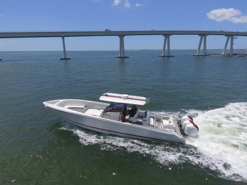 Slide: The Image of 2017 Nor-Tech 390 Sport boat cruising under a bridge on a sunny day. - 16