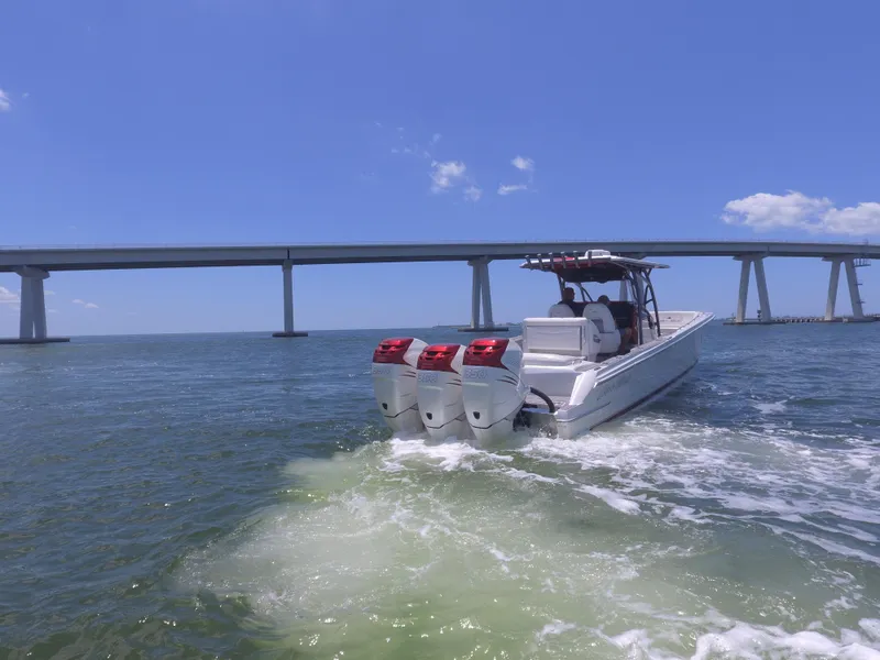 Slide: The Image of 2017 Nor-Tech 390 Sport boat cruising under a bridge on a sunny day. - 22