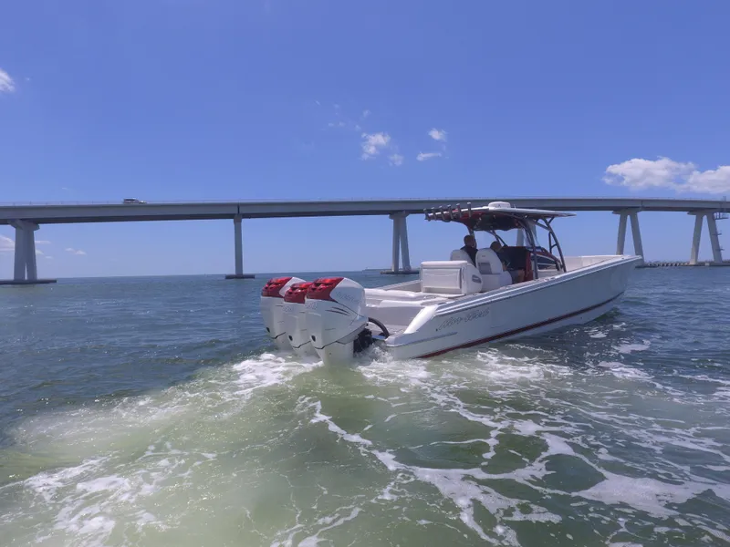 Slide: The Image of 2017 Nor-Tech 390 Sport boat cruising under a bridge on a sunny day. - 23