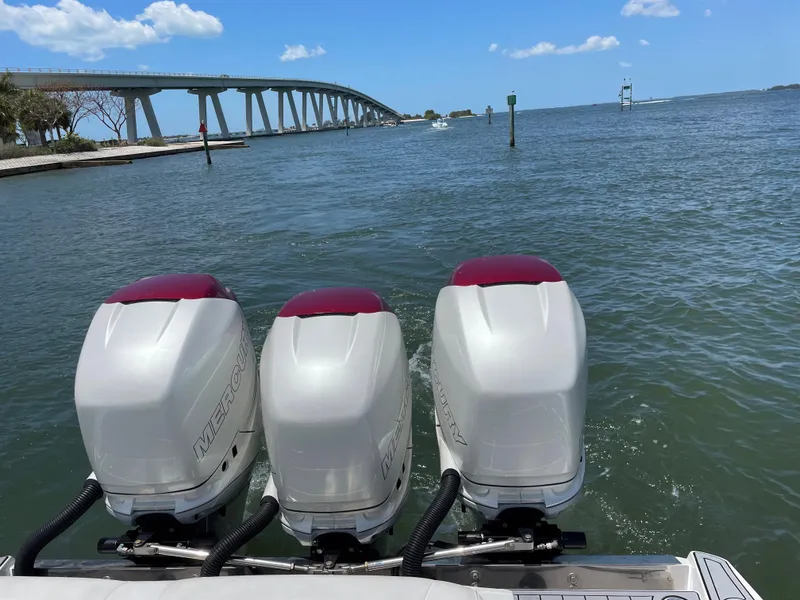 Slide: The Image of 2017 Nor-Tech 390 Sport boat with triple engines on the water near a bridge. - 32