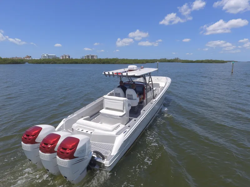 Slide: The Image of 2017 Nor-Tech 390 Sport boat with triple outboard engines cruising on a sunny day. - 5