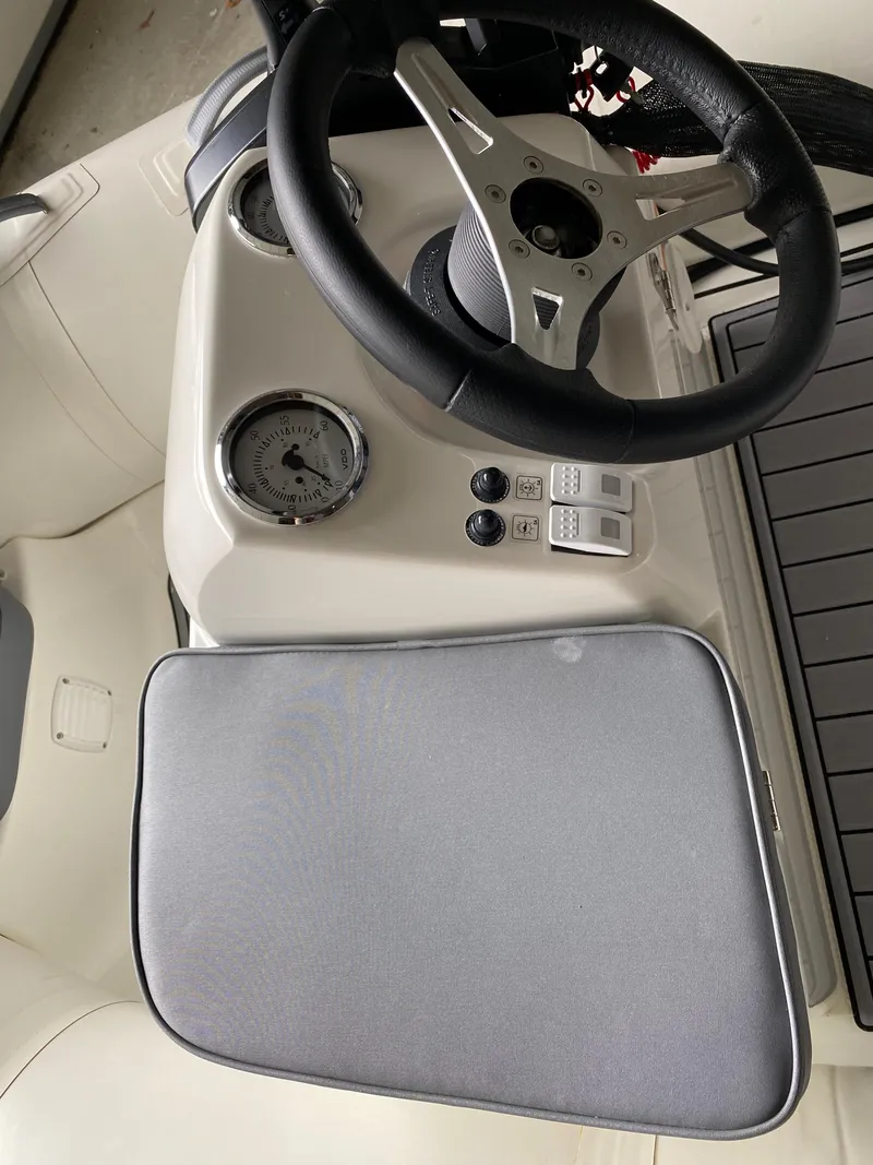 Slide: The Image of 2022 Brig Falcon 330 boat dashboard with steering wheel and controls. - 3