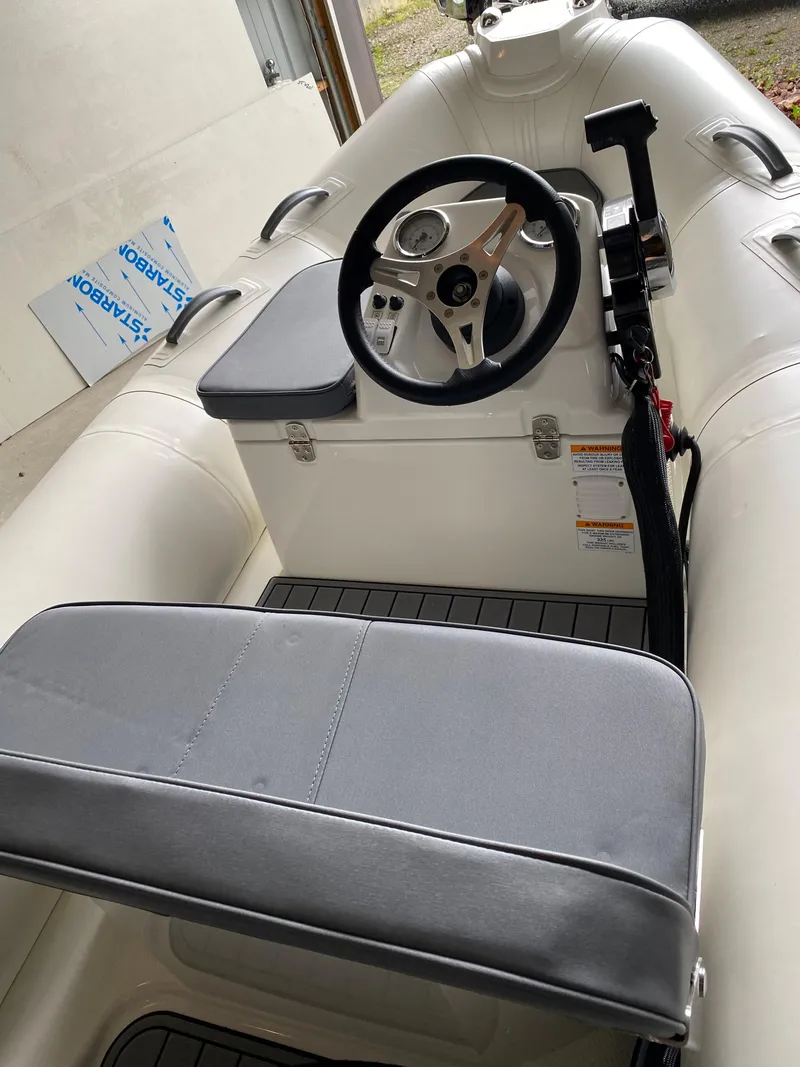 Slide: The Image of 2022 Brig Falcon 330 inflatable boat interior with steering wheel and seating. - 5