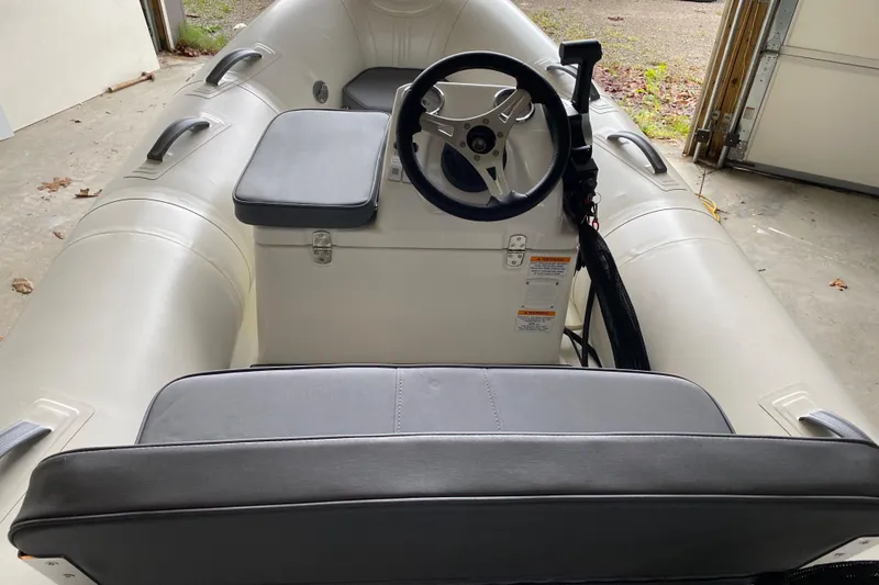 Slide: The Image of 2022 Brig Falcon 330 inflatable boat interior with steering console and seating. - 8