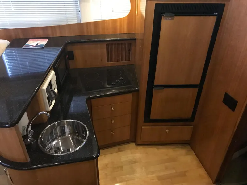 Slide: The Image of 2002 Carver 396 Aft Cabin MY kitchen with wood cabinetry, sink, and appliances. - 23