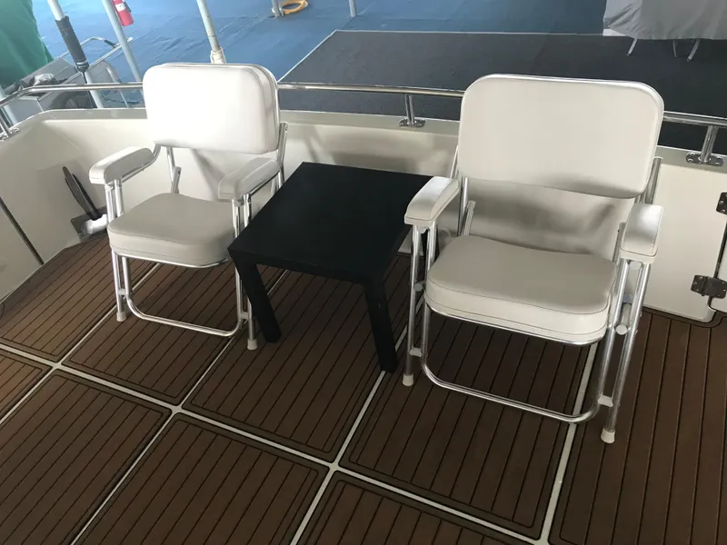 Slide: The Image of Two white chairs and a black table on a 2002 Carver 396 Aft Cabin MY yacht deck. - 29