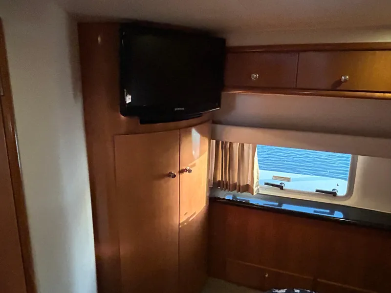 Slide: The Image of Interior of 2002 Carver 396 Aft Cabin MY with TV and wooden cabinetry. - 45