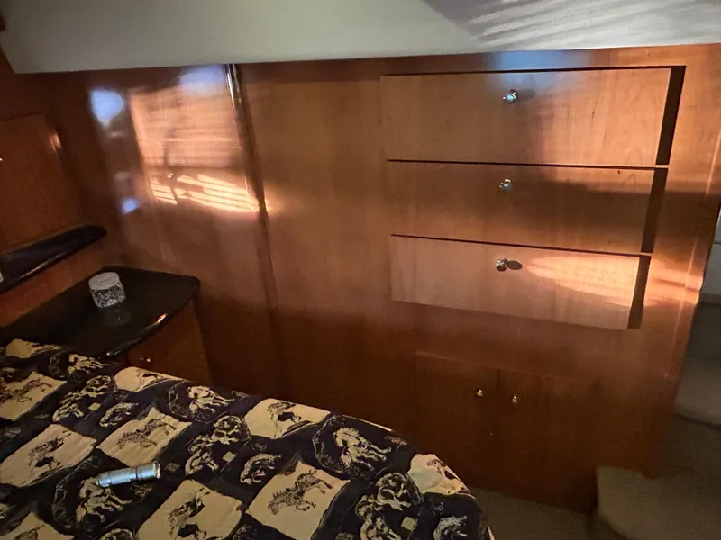 Slide: The Image of Interior of 2002 Carver 396 Aft Cabin MY with wood paneling and patterned bedding. - 44