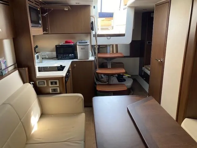 Slide: The Image of Interior of 2019 Sea Ray 350 Sundancer yacht with kitchen, seating, and stairs. - 13