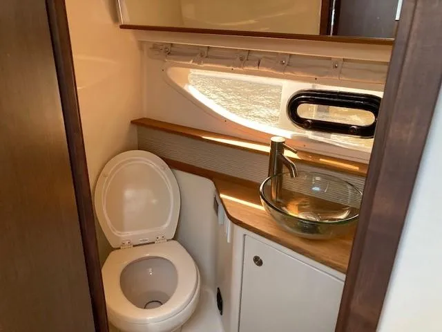 Slide: The Image of 2019 Sea Ray 350 Sundancer bathroom with modern sink and toilet. - 15