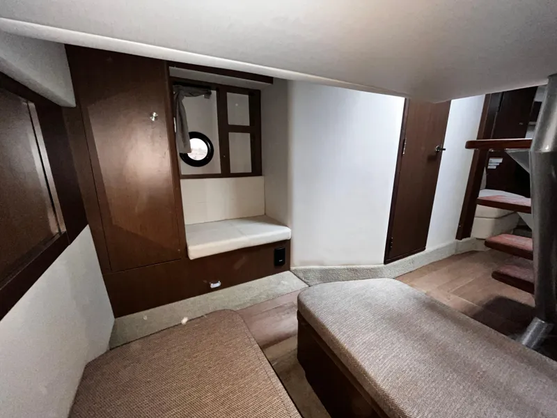 Slide: The Image of 2019 Sea Ray 350 Sundancer cabin interior with wooden finishes and seating area. - 21