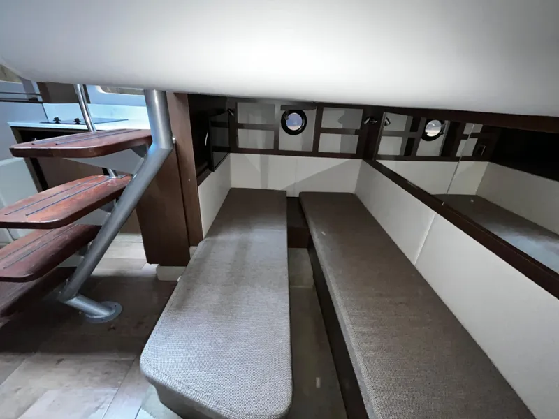 Slide: The Image of 2019 Sea Ray 350 Sundancer interior with seating and wooden stairs. - 23