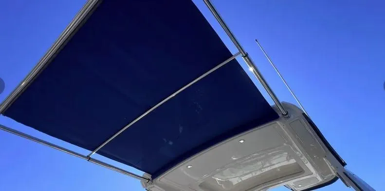 Slide: The Image of 2019 Sea Ray 350 Sundancer boat canopy against clear blue sky. - 26