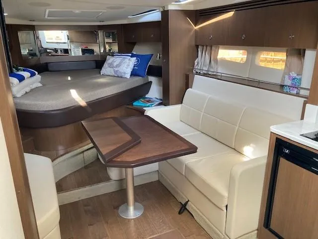 Slide: The Image of 2019 Sea Ray 350 Sundancer interior with bed, seating, and table. - 9