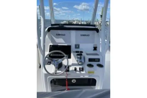 Slide: The Image of 2019 Sea Pro 239 Center Console boat dashboard with steering wheel and navigation controls. - 2