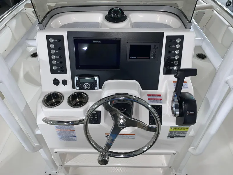 Slide: The Image of 2024 Robalo R222 Center Console boat dashboard with steering wheel and electronic controls. - 10