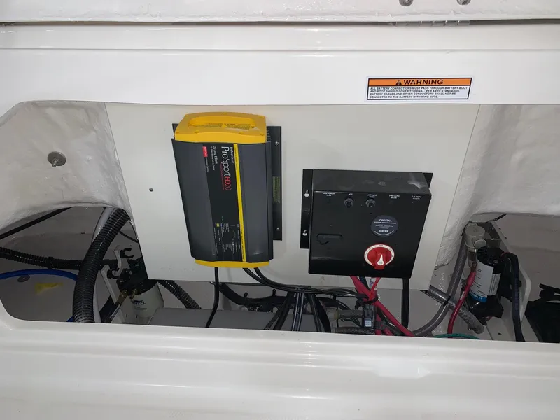 Slide: The Image of 2024 Robalo R222 Center Console electrical panel and battery charger. - 18