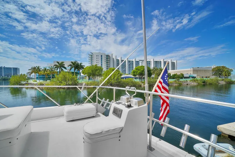 Slide: The Image of 1991 Jones-Goodell Yachtfish on serene waters with cityscape backdrop - 12